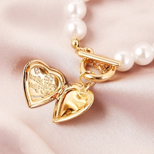 Detail of gold locket heart with I Love You engraving and baroque pearls