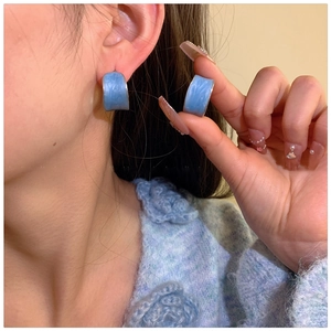 Detail of blue drip oil C-shaped stud earrings with water ripple texture for women