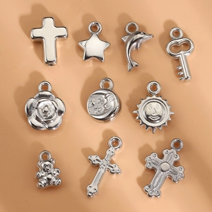 Dettaglio dei ciondoli argentati a forma di croce e stella per la creazione di gioielli