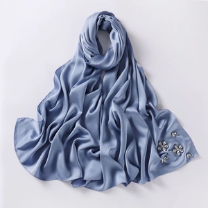 Detailed view of grey blue chiffon hijab with elegant handmade rhinestone flower accents