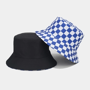 Detail of reversible bucket hats in solid black and blue-white checkerboard patterns