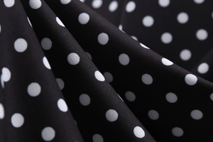 Macro detail of high-quality black fabric with white polka dots for vintage dresses