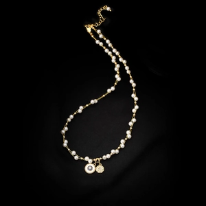 Gros plan d'un collier de perles plaqué or 18 carats avec pendentifs vintage