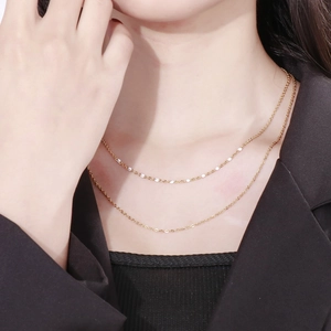 Détail d'un collier double épaisseur en acier titane doré sur un mannequin style bohème