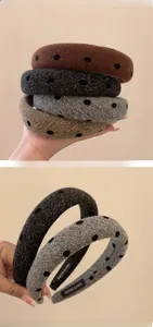 Close-up of handmade knitted polka dot headbands showing wool texture and logo