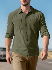 Detail of olive green corduroy workwear shirt with dual pockets in an outdoor scene