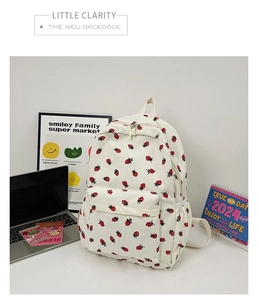 Detail shot of cream white corduroy backpack with cute red strawberry print patterns