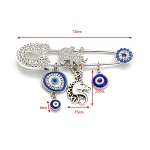 Macro detail of silver-toned evil eye safety pin brooch with 72mm size dimensions