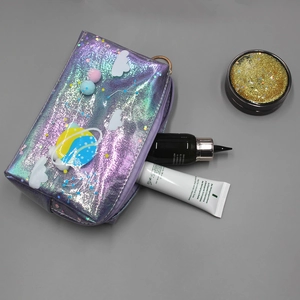 Close-up of laser purple planet makeup bag with fluffy pompons and star patterns