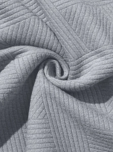 Gros plan détaillé du tissu en maille gris clair avec motifs à côtes et losanges