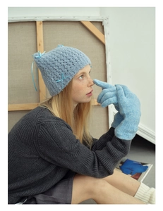 Detailed knit texture of wool blend gloves and a beanie featuring a cute bow detail