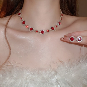 Nahaufnahme des roten Edelstein-Schmucksets mit Kette und Ohrringen am Modell