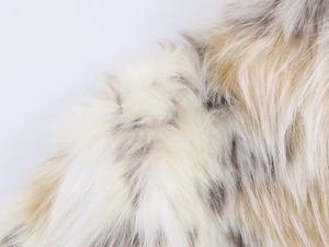 Macro view of plush faux fur texture in cream and beige tones for women's winter coat