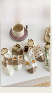 Detail of assorted khaki cotton ankle socks with floral patterns and stripe designs