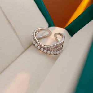 Macro detail of adjustable silver ring with zircon stones and white pearls in jewelry box
