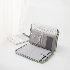Detailed interior of light green iPad bag with compartments for keyboard and cables