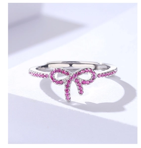 Detailed macro view of silver bow ring featuring pavé-set rose pink cubic zirconia