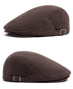 Detail view of dark brown cotton flat cap showing bronze metal buckle and neat stitching