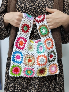 Detail of colorful handmade crochet tote bag featuring bohemian granny square patterns