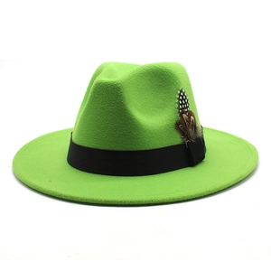 Detail of bright green wool fedora hat with black ribbon and natural feather decoration