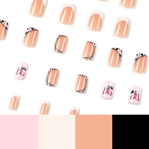 French tip press-on nails with pink glitter hearts and black dot patterns