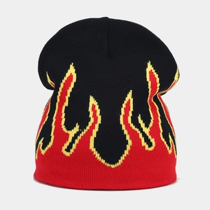 Close-up of knit beanie featuring black base with vibrant red and yellow flame pattern jacquard