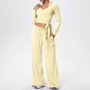 Détail d'un ensemble de yoga élastique avec haut à nouer et pantalon large jaune crème