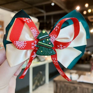 Detailed close-up of a double-layered Christmas ribbon hair clip with a small green tree