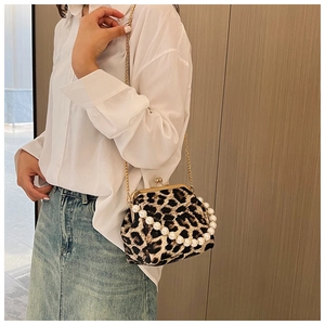 Detail of leopard print crossbody bag with pearl handle and golden chain strap
