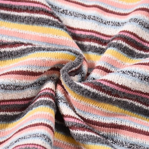 Close-up of vibrant rainbow striped knit fabric with soft loop texture and multi-colored yarn