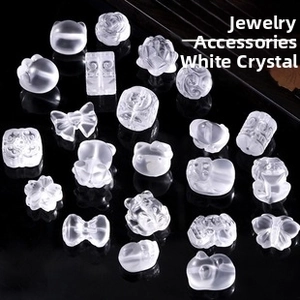 Macro shot of 14k gold-plated white crystal charms in floral and animal shapes for DIY