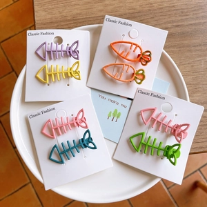 Close-up of cute matte candy color fishbone and carrot hair clips for girls on display cards