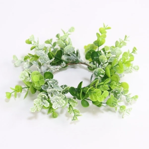 Green artificial eucalyptus candle ring wreath with white frosted plastic leaves on white background