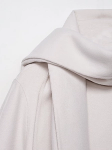 Close-up of light beige wool blend coat showing high-quality fabric texture and stitching