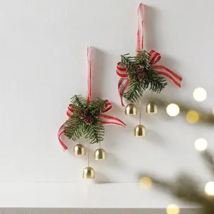 Handmade Christmas wreath pendant with pine cones and golden bells on white background