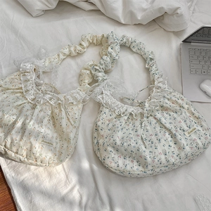 Détail de sacs en toile à fleurs avec bordure en dentelle et anses plissées jaune et bleu
