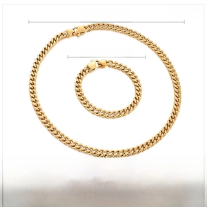 Close-up of gold stainless steel necklace and bracelet set with durable link texture