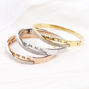 Détail de bracelets superposés en or et argent avec chiffres romains et cristaux brillants