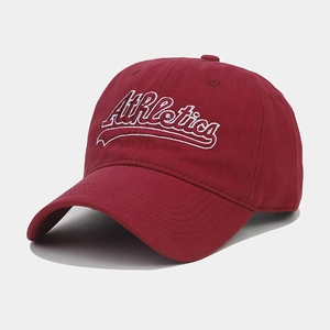 Detail of wine red baseball cap with white Athletics embroidery and curved brim