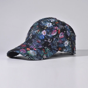 Close-up of distressed denim baseball cap with floral prints and embroidered text detail