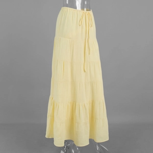 Detail of light yellow tiered maxi skirt showing cotton crinkle fabric and drawstring waist