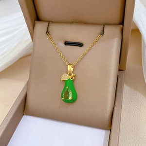 Close-up of gold pear-shaped green enamel pendant with water drop gemstone inlay