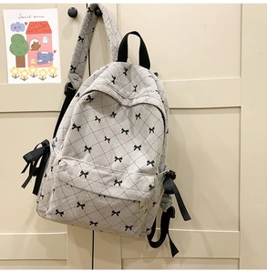 Detail of corduroy backpack with black ribbon bows and diamond quilted stitching pattern