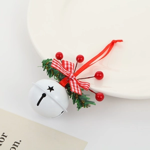 Detail showing white metal bell with red plaid bow, pine needles and festive red berries
