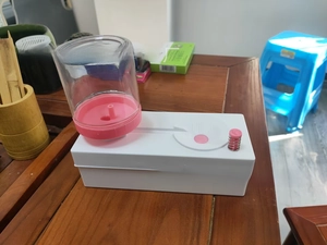 Detailed view of paintbrush rinser with water circulation system and pink control button