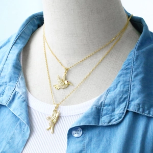 Detail of gold hummingbird pendants with sparkling zircons and red gemstone eyes