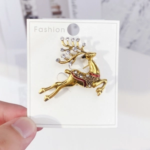 Golden reindeer brooch with crystals and red enamel in a graceful leaping pose
