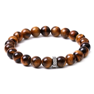 Macro detail of natural tiger eye beads and textured silver spacer bead on a beaded bracelet