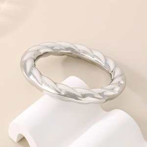 Macro shot of silver twisted rope texture on a polished hollow stainless steel bangle