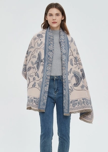 Detailed view of beige paisley shawl with blue floral patterns and tassel fringe edge